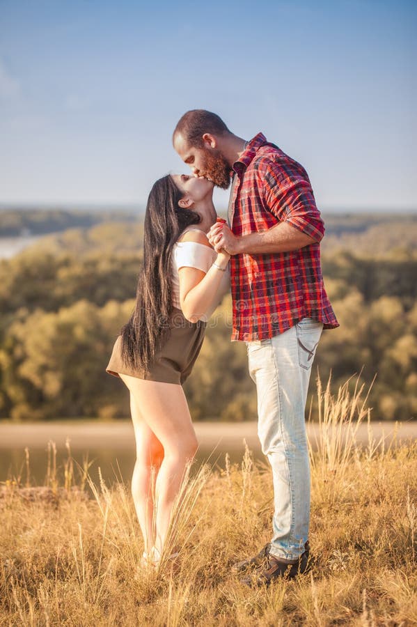 Brunette e brutale ragazzo con una storia d'amore alla barba. abbracci e fotografia stock