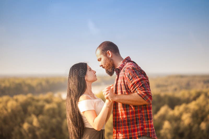Brunette e brutale ragazzo con una storia d'amore alla barba. abbracci e immagine stock