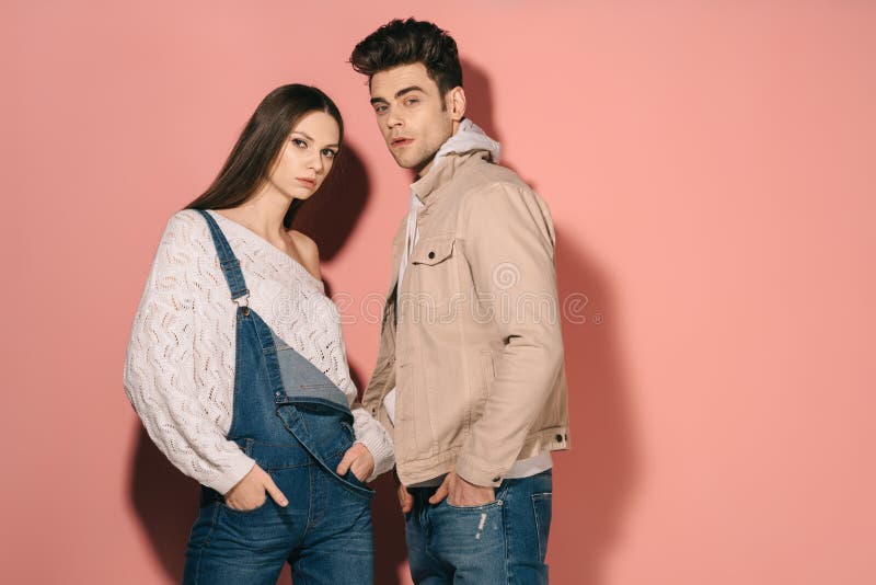 Brunette en mooie vriendin in denim overalls en knappe vriendje met handen in zakken royalty-vrije stock foto's Brunette en mooie vriendin in denim overalls en knappe vriendje met handen in zakken royalty-vrije stock foto's