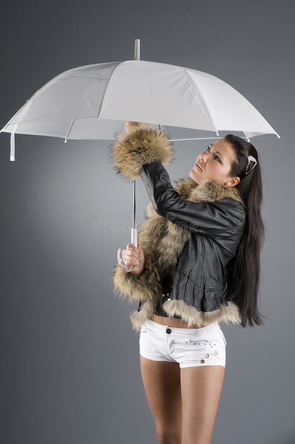 Nice brunette opening her umbrella under rain. Nice brunette opening her umbrella under rain