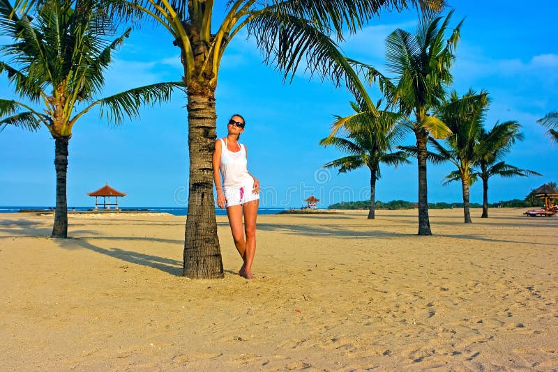 Brunette girl standing on the lonely sand beach