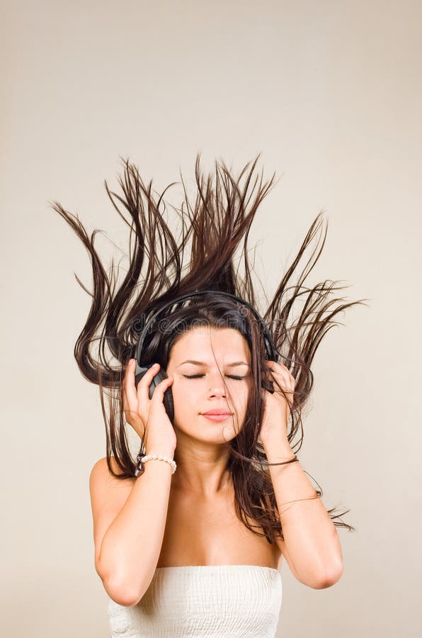 Brunette immergé dans les écouteurs s'usants de musique. image libre de droits Brunette immergé dans les écouteurs s'usants de musique. image libre de droits