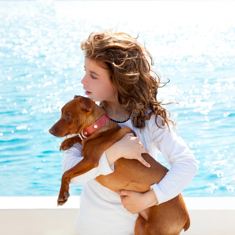 Brunette kid girl with dog on the sea view from a boat. Lovely european female stock images, royalty-free photos and pictures