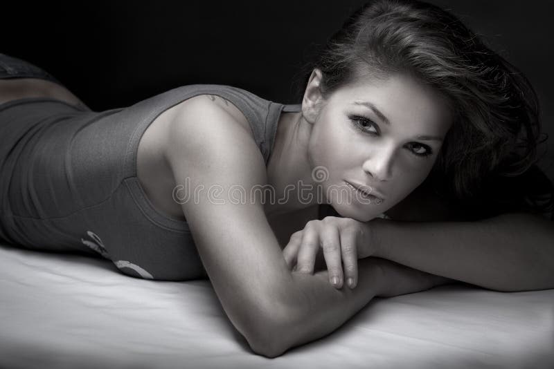 Brunette laying on her bed royalty free stock photo
