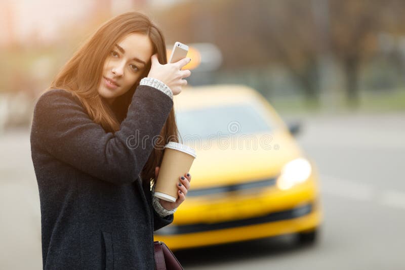 Brunette met koffie dichtbij taxi stock afbeelding Brunette met koffie dichtbij taxi stock afbeelding