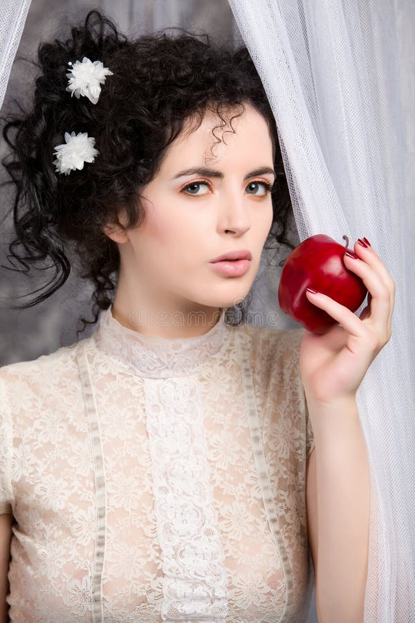 Brunette model in lace blouse holding apple