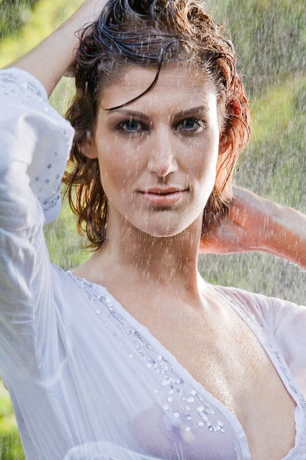 Brunette in white blouse standing in the rain