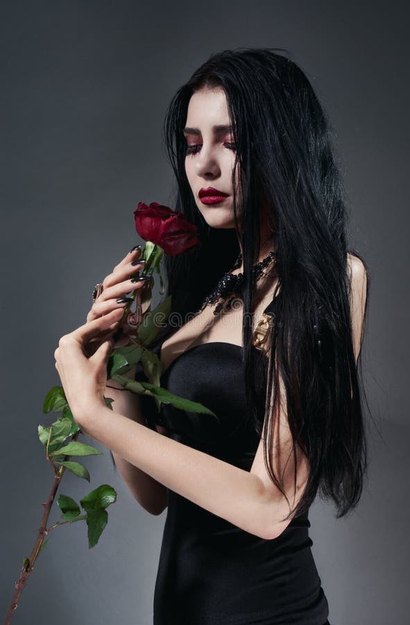 Brunette woman in black dress with red rose