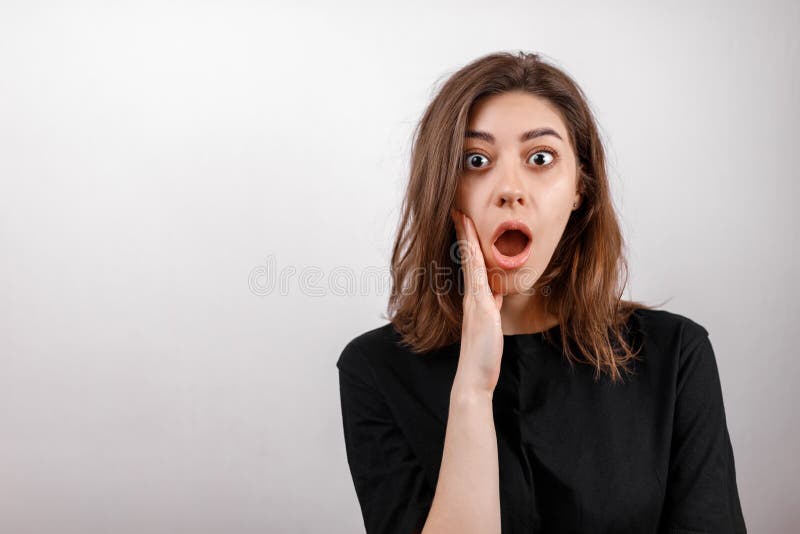 Brunette woman on a white background in a black shirt. emotions stock photo Brunette woman on a white background in a black shirt. emotions stock photo
