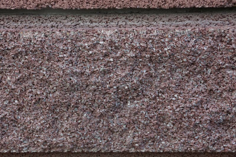 Brunt stenar textur av ett stycke av granit i väggen arkivbild