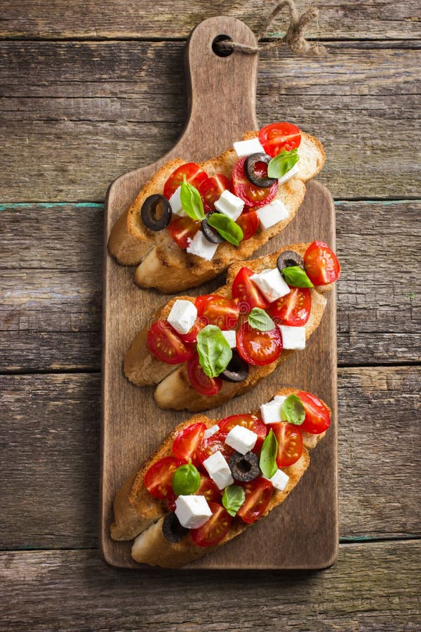 Bruschetta com tomate, queijo feta e manjericão foto de stock royalty free