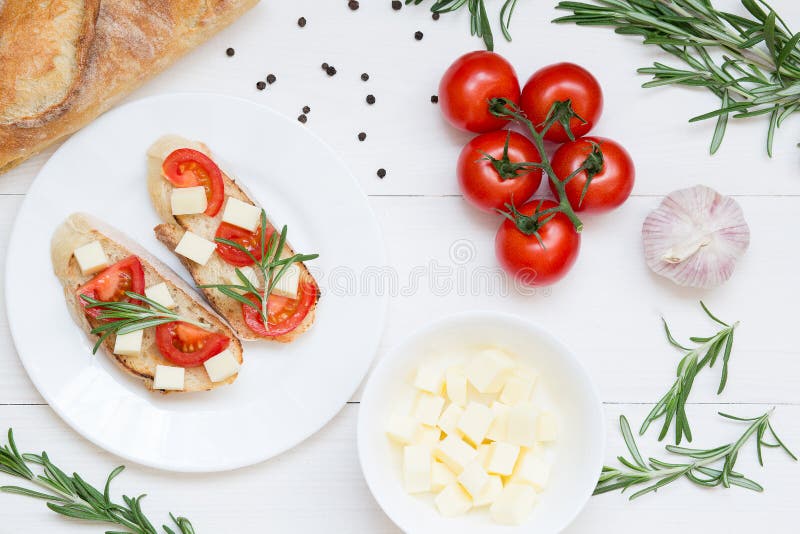 Bruschetta grzanki z mozzarellą, czereśniowymi pomidorami i świeżymi ogrodowymi rozmarynami, Odgórny widok z przestrzenią dla twó obraz royalty free Bruschetta grzanki z mozzarellą, czereśniowymi pomidorami i świeżymi ogrodowymi rozmarynami, Odgórny widok z przestrzenią dla twó obraz royalty free
