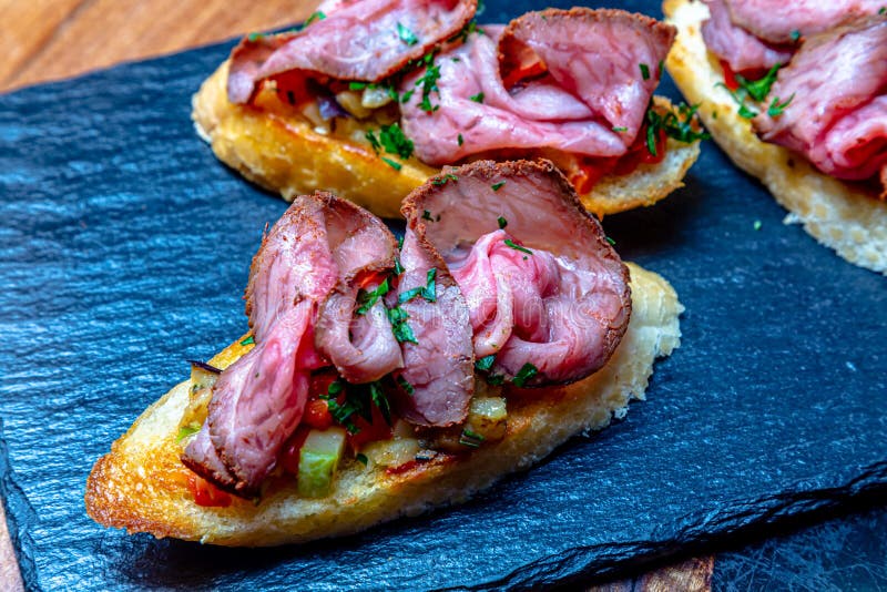 Bruschetta with Ham or Roast Beef is on a Slate Plate Stock Image