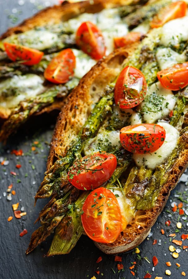 Bruschetta mit gegrilltem grünem Spargel, Mozzarellakäse und Kirschtomate lizenzfreies stockbild Bruschetta mit gegrilltem grünem Spargel, Mozzarellakäse und Kirschtomate lizenzfreies stockbild