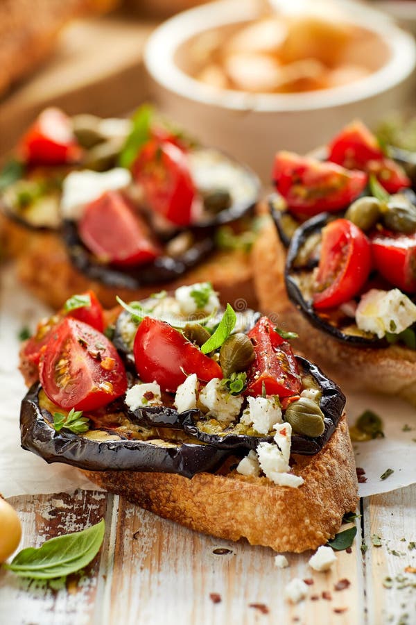 Bruschetta Mit Gegrillter Aubergine, Kirschtomaten, Feta, Kapriolen Und ...