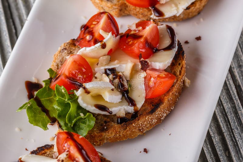 Bruschetta with Tomatoes, Lettuce, Camambert, Balsamic Vinegar Stock