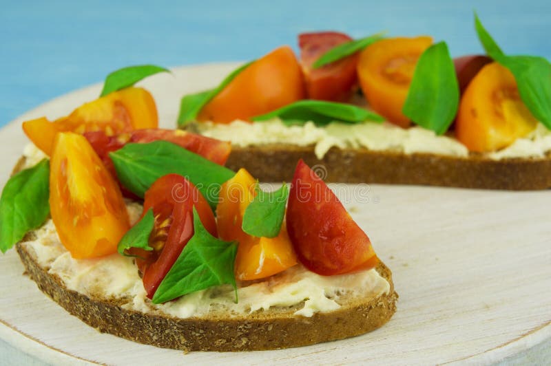 Bruschetta z miękkim serem, basilem i czereśniowymi pomidorami na drewnie, fotografia stock Bruschetta z miękkim serem, basilem i czereśniowymi pomidorami na drewnie, fotografia stock