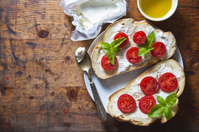 Bruschetta z miękkim serem, basilem i czereśniowymi pomidorami na drewnie, fotografia stock Bruschetta z miękkim serem, basilem i czereśniowymi pomidorami na drewnie, fotografia stock