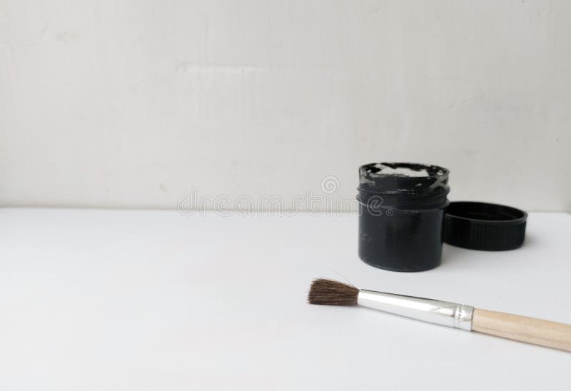 Brush and Can with Black Paint on a White Background. the Paint is Open