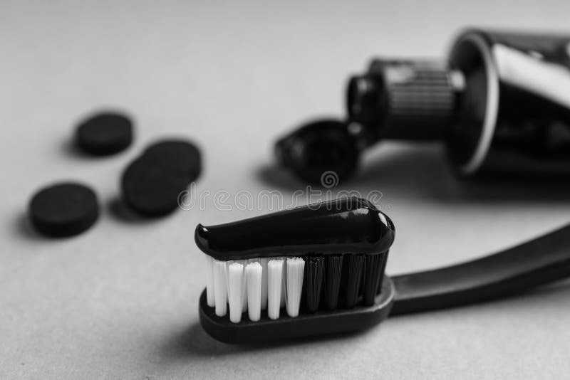 Brush with Charcoal Toothpaste on Light Grey Background, Closeup Stock