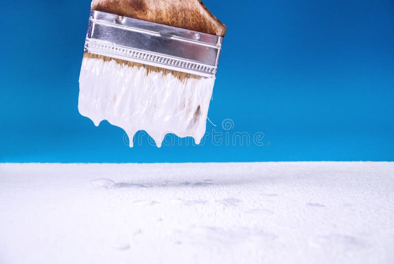 With a Brush Dripping White Paint on the Surface Does the Painting