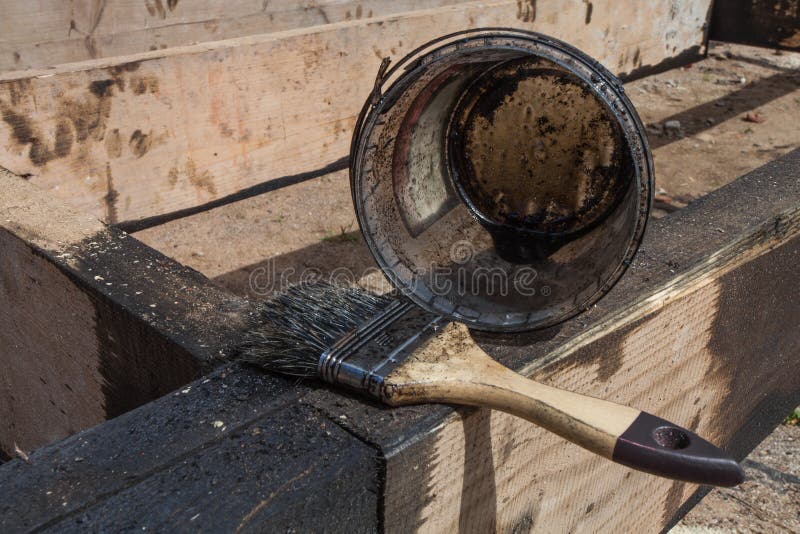 The brush for painting black coal tar or bitumen at surface of terrace for waterproofing stock image
