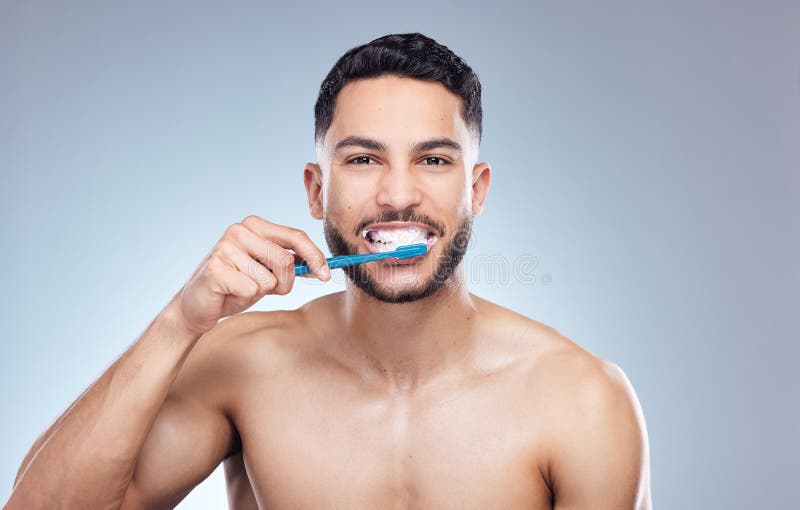 Brush in Slow Circles. a Young Man Brushing His Teeth Against a Studio ...