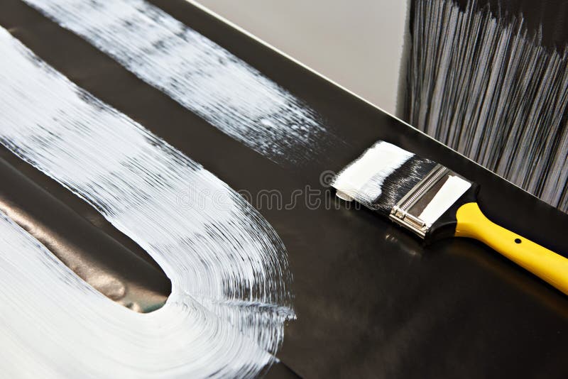 Brush and white paint on black surface royalty free stock photography Brush and white paint on black surface royalty free stock photography