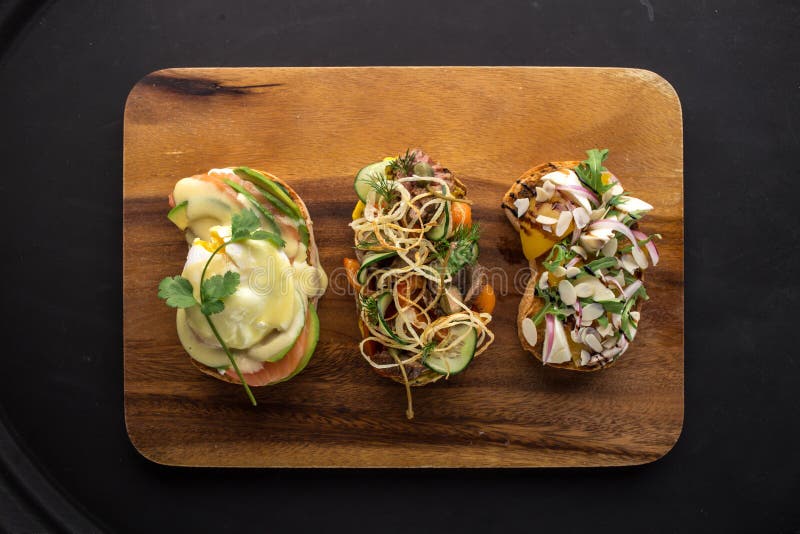 Brushetta bröd eller autentiska traditionella spanska tapas på träbräde på svart bakgrund royaltyfria bilder Brushetta bröd eller autentiska traditionella spanska tapas på träbräde på svart bakgrund royaltyfria bilder