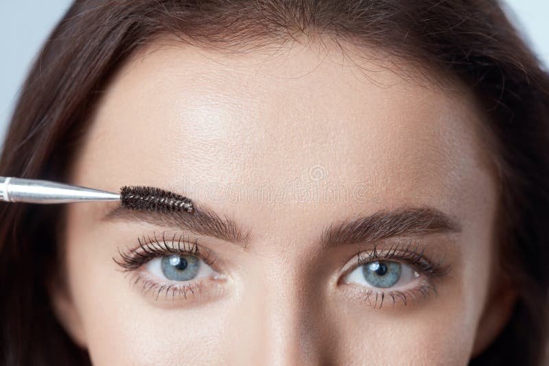 Brushing Eyebrows. Woman Shaping Brows With Brush. Beautiful Girl Close Up Portrait.