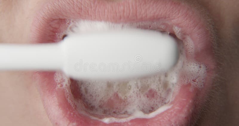 Brushing Teeth with a Paste and Tooth Brush a Close up Shot of Woman Lips