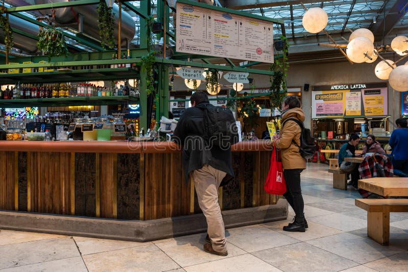 Brussels Old Town, Belgium - People waiting at a foodstall in the Wolf foodhall