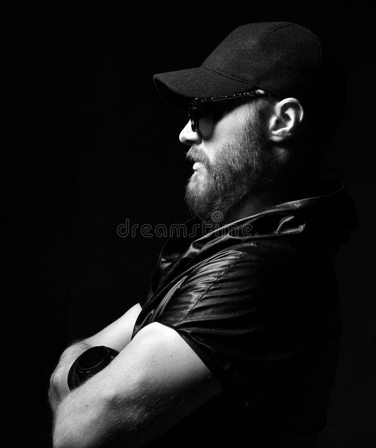 Brutal man in leather jacket, black cap and round sunglasses royalty free stock image Brutal man in leather jacket, black cap and round sunglasses royalty free stock image
