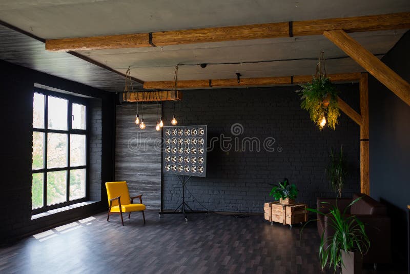 Brutal modern interior in a dark color with a leather sofa and large window. Loft style living room royalty free stock photos Brutal modern interior in a dark color with a leather sofa and large window. Loft style living room royalty free stock photos