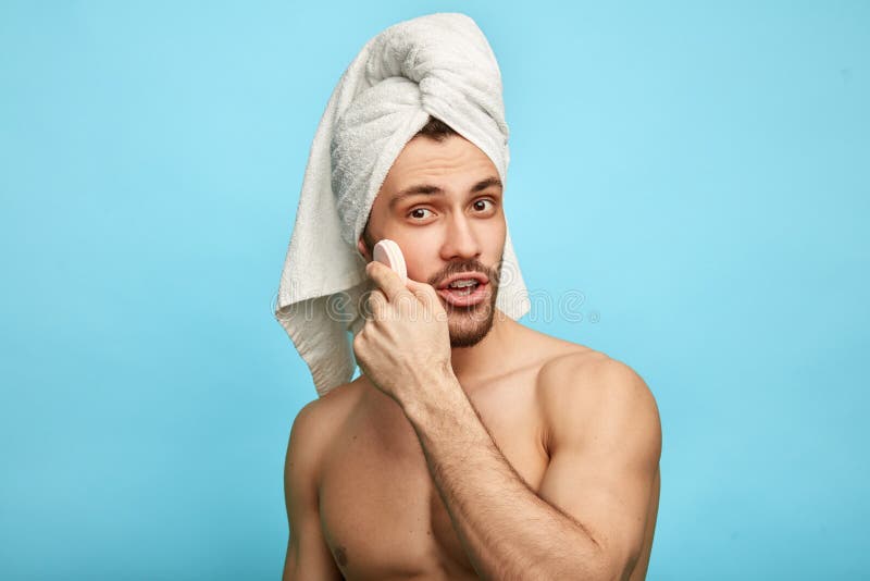 Brutal naked male cares of beauty and skin. Facial treatments