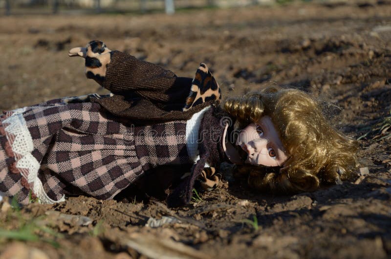 Broken porcelain doll lying on the ground. Broken porcelain doll lying on the ground