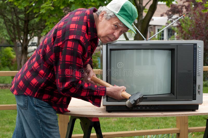 Man getting ready to break an old TV set. Man getting ready to break an old TV set