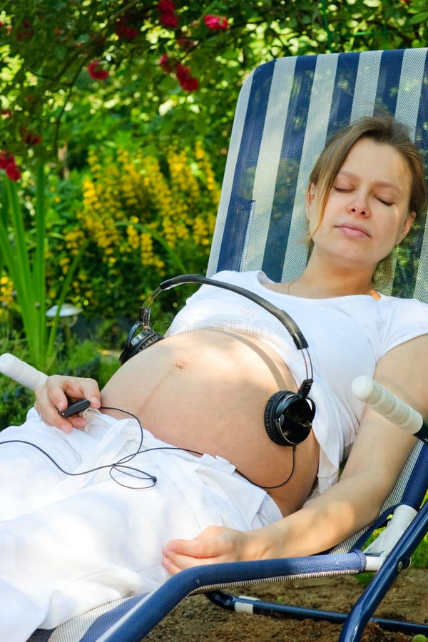 Headphones on a pregnant woman's belly. Headphones on a pregnant woman's belly