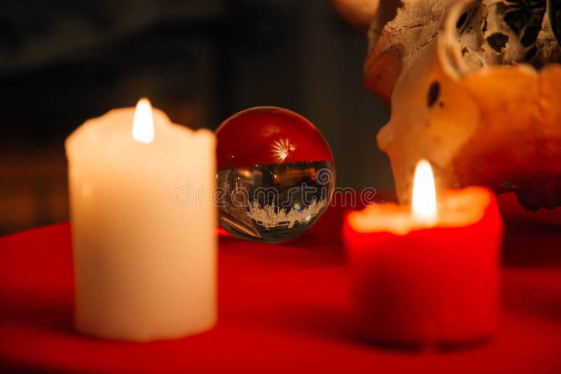 Burning candles and crystal ball. Wicca, esoteric, divination and occult background with vintage magic objects for mystic rituals. Burning candles and crystal ball. Wicca, esoteric, divination and occult background with vintage magic objects for mystic rituals