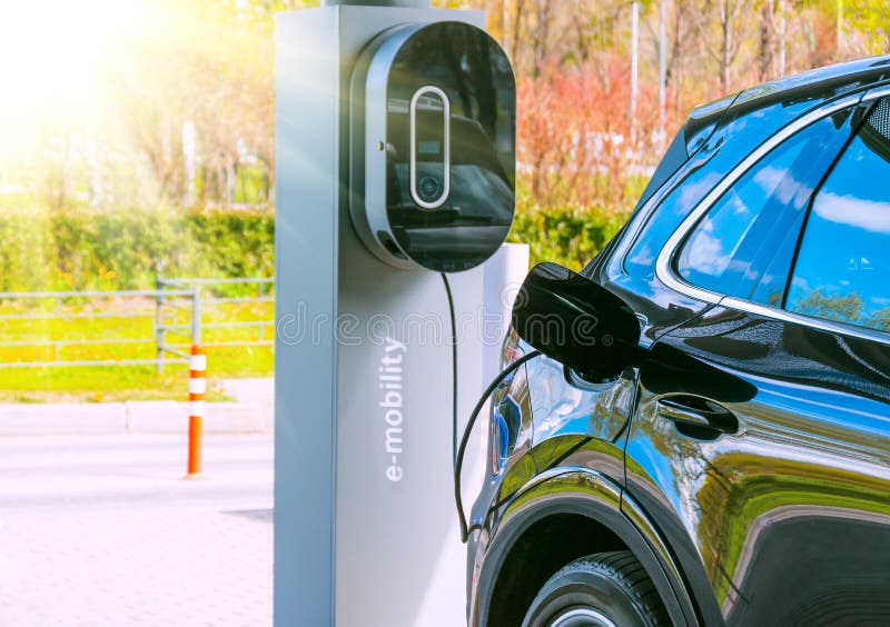 Refueling for cars e-mobility. Charging an electric car at hybrid engine gasoline and electricity. Sunlight as an electric renewable energy concept. Refueling for cars e-mobility. Charging an electric car at hybrid engine gasoline and electricity. Sunlight as an electric renewable energy concept.