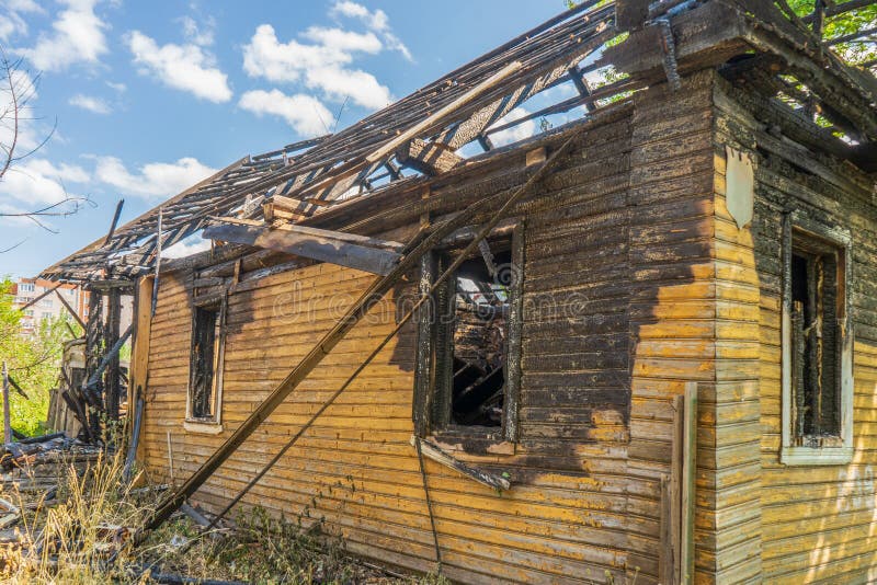 Bränt trähus på gatan. övergiven förstörd bostadsbyggnad. konsekvenser av brandtragedi. brandkoncept royaltyfri fotografi