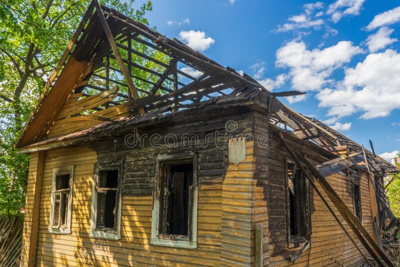 Bränt trähus på gatan. övergiven förstörd bostadsbyggnad. konsekvenser av brandtragedi. brandkoncept royaltyfri fotografi