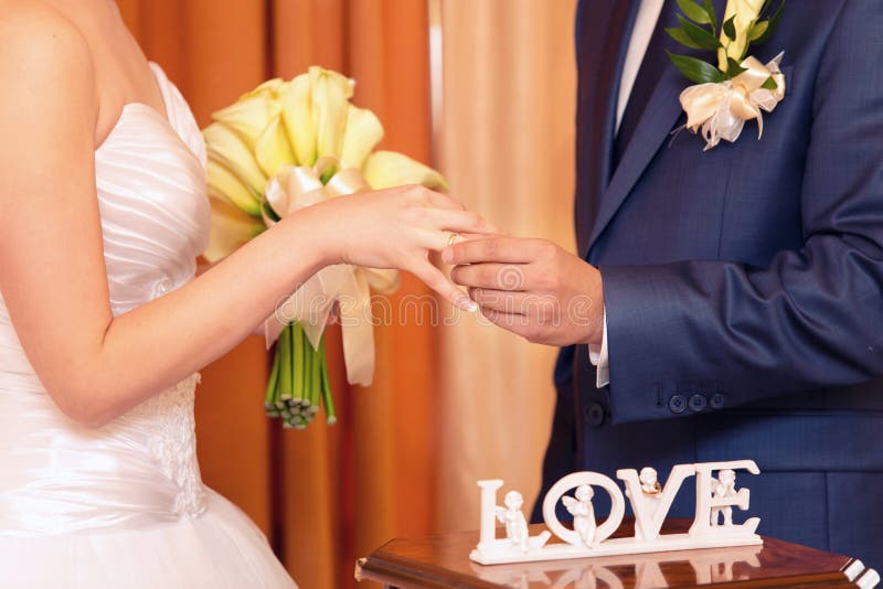 Bräutigam kleidet einen Ring auf Finger zur Braut stockfotografie Bräutigam kleidet einen Ring auf Finger zur Braut stockfotografie