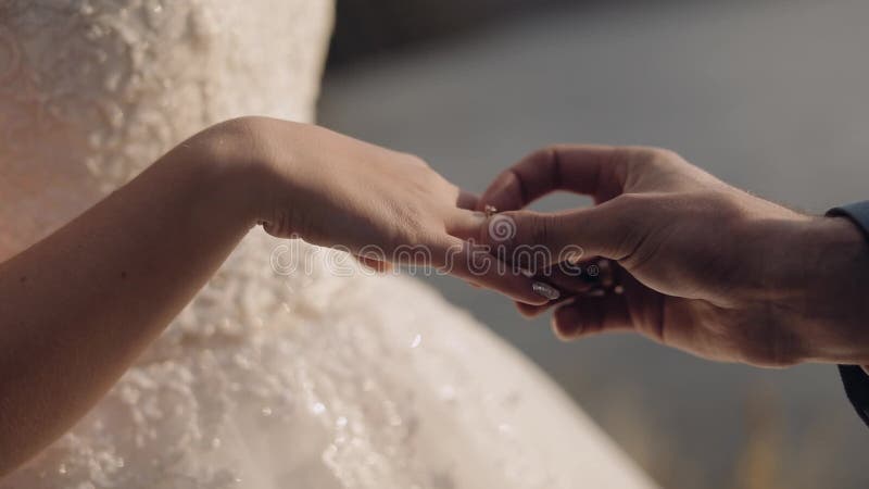 Bräutigam sieht an den Finger der Braut ein Verlobungsring Hochzeitspaare