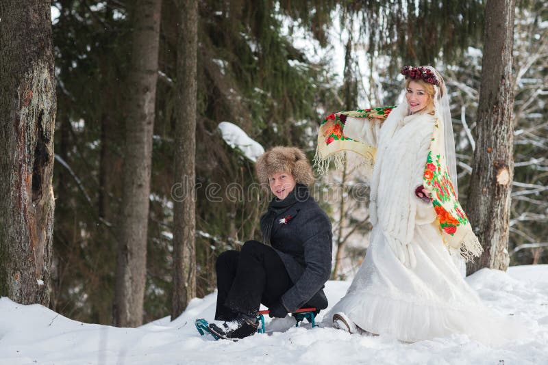 Bräutigam und Braut im kalten Winterwald mit dem großen hölzernen Schlitten lizenzfreies stockfoto Bräutigam und Braut im kalten Winterwald mit dem großen hölzernen Schlitten lizenzfreies stockfoto