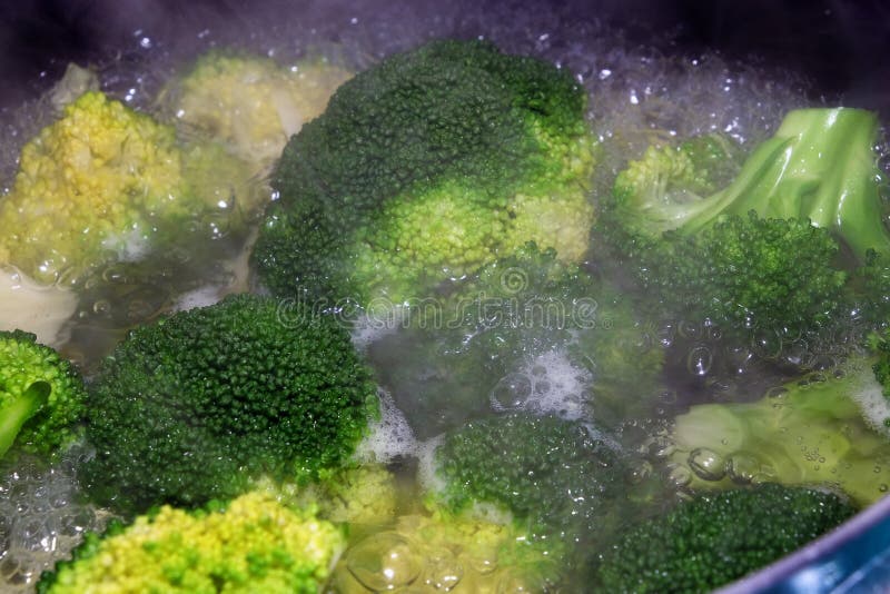 Brócolis que cozinham na água a ferver na bandeja em um hob imagens de stock royalty free Brócolis que cozinham na água a ferver na bandeja em um hob imagens de stock royalty free