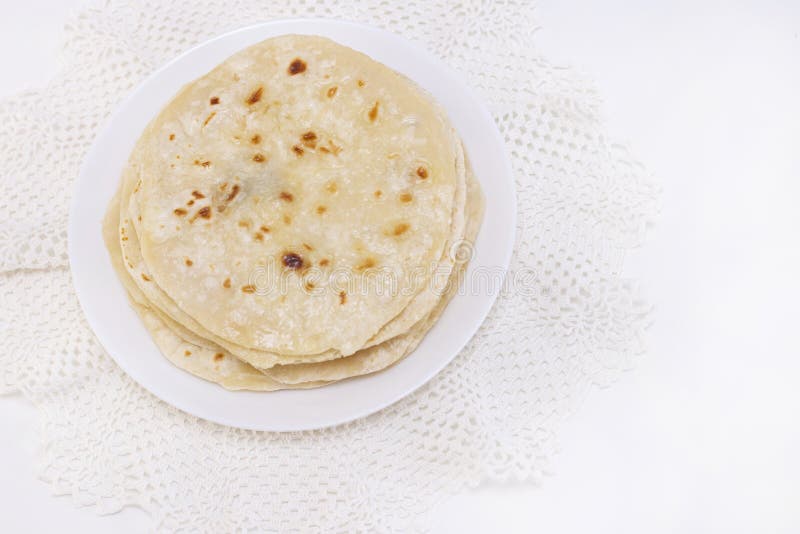 Bröd av indiskt chapati chapati på en vit platta på en vit bakgrund tillagning i torr form fotografering för bildbyråer