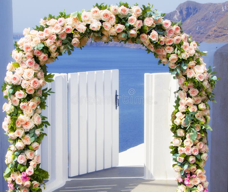 Bröllop på Santorini Härlig båge som vid de flesta dekoreras med blommor av rosor med den blåa kyrkan av Oia, Santorini, romantis fotografering för bildbyråer Bröllop på Santorini Härlig båge som vid de flesta dekoreras med blommor av rosor med den blåa kyrkan av Oia, Santorini, romantis fotografering för bildbyråer