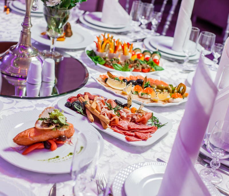 Brölloptabell som tjänas som med smakliga mål, kallt kött för antipastouppläggningsfat, fiskuppläggningsfat, ostuppläggningsfat F arkivfoton Brölloptabell som tjänas som med smakliga mål, kallt kött för antipastouppläggningsfat, fiskuppläggningsfat, ostuppläggningsfat F arkivfoton