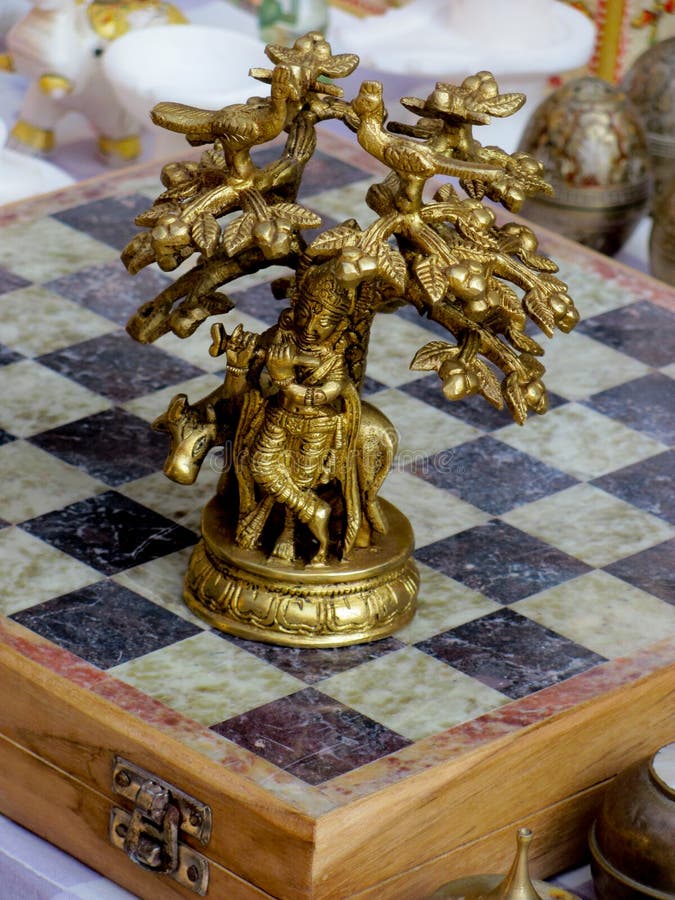 Bronze chess piece showing the lord krishna sitting under a tree and playing the flute. Bronze chess piece showing the lord krishna sitting under a tree and playing the flute